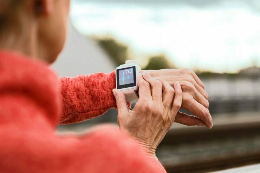 Femeie în vârstă care folosește ceasul inteligent în timpul activităților sportive