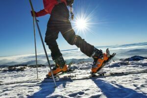 Cei mai buni clapari ski - Persoană necunoscută care merge pe munte cu schiuri și clapari