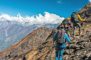 Grup de drumeții folosind bețe de trekking pe un traseu montan.