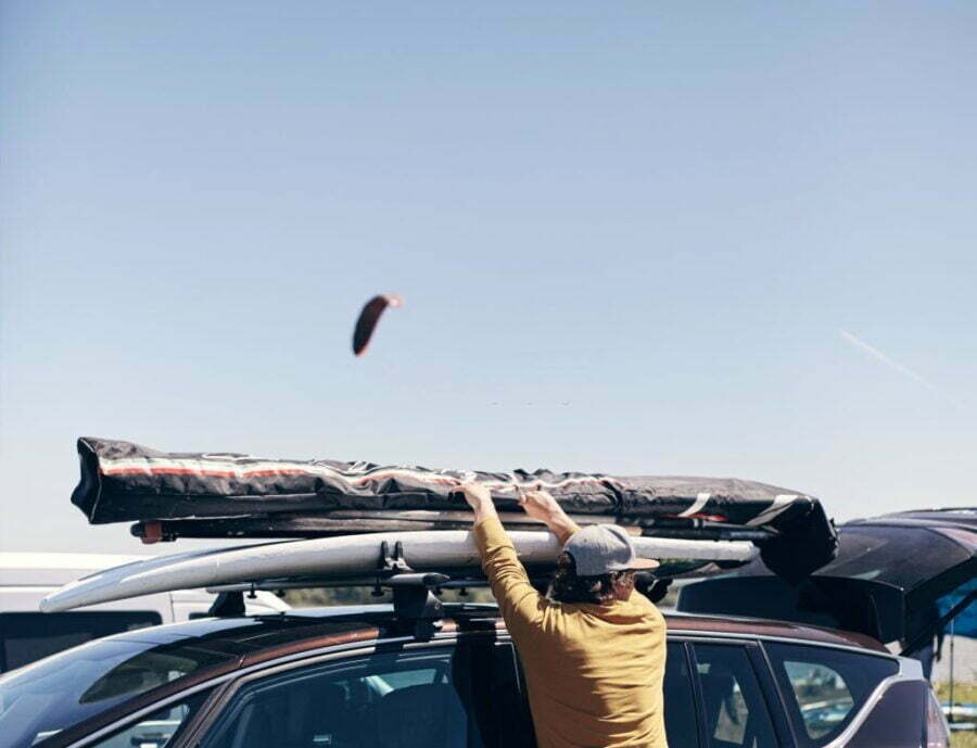 Persoană instalând un cort de plafon auto compact pe un SUV