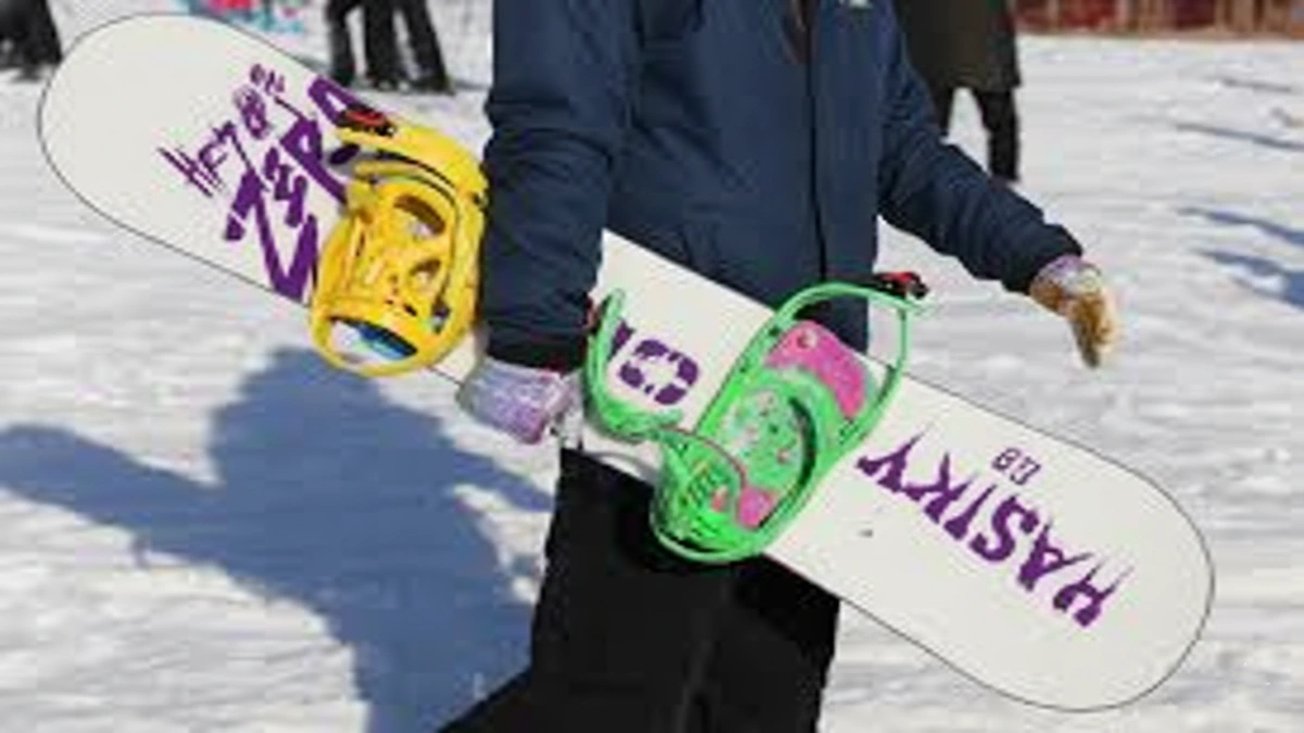 placă snowboard freestyle cu legături colorate purtată pe pârtie de snowboarder