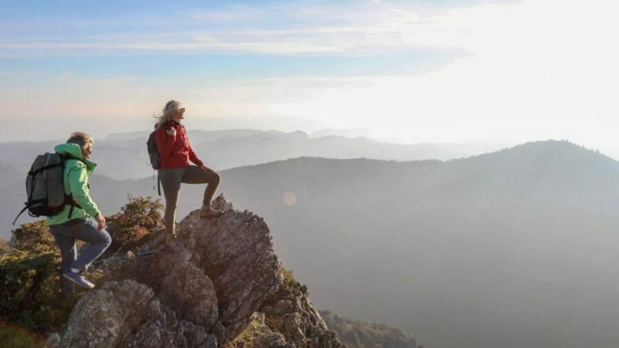 Femeie purtând pantaloni de drumeție pentru dame și privind spre peisajul natural.