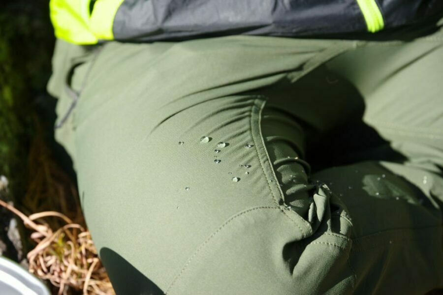 Femeie purtând pantaloni de drumeție cu picături de ploaie pe țesătură
