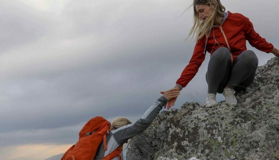 Tânăra îi oferă mamei ei o mână de ajutor purtând pantaloni de drumeție pentru femei