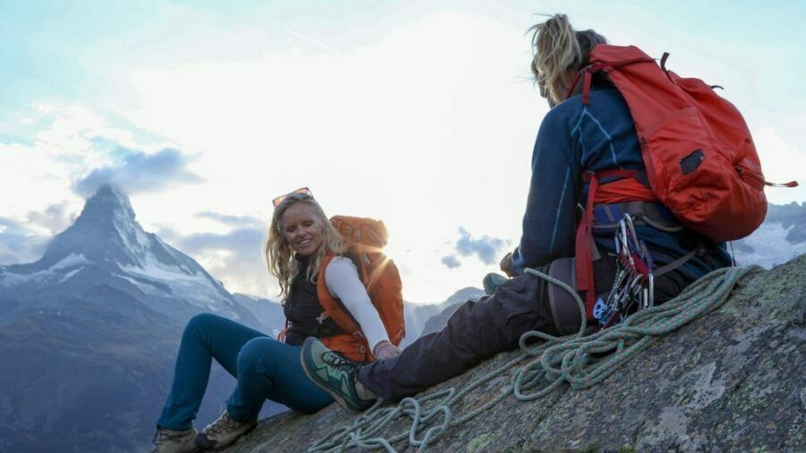 Femei în pantaloni de drumeție se odihnesc în fața Matterhorn-ului