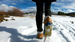 O femeie care merge prin zăpadă purtând cizme de iarnă dama elegante și rezistente.