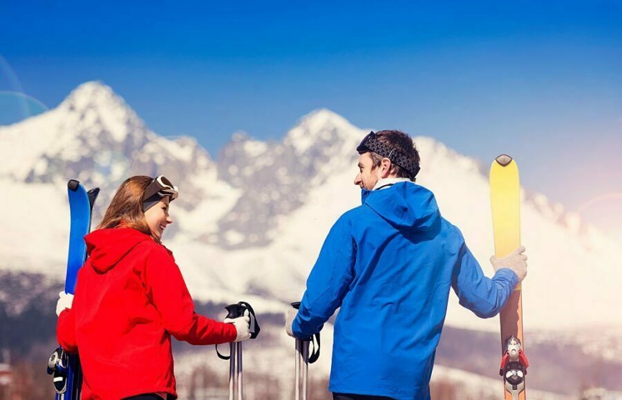 Doi schiori cu echipament complet, pregătiți pentru coborâre.