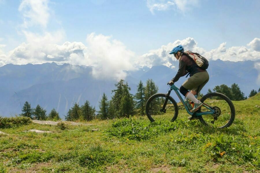 Ciclistă de munte cu bicicletă într-un peisaj montan