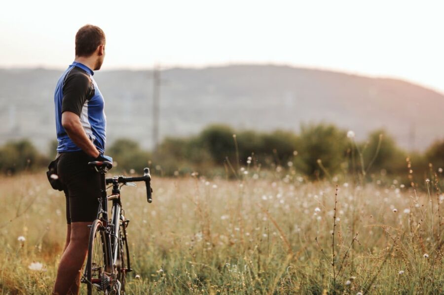 Omul_impinge_bicicleta_de-a_lungul_campului