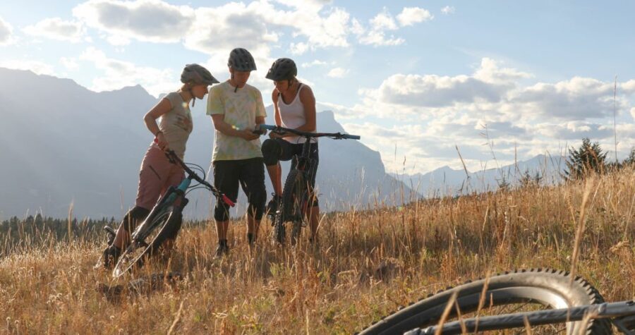 Trei_ciclisti_cu_biciclete_consultand_telefonul_mobil_pentru_indicatii
