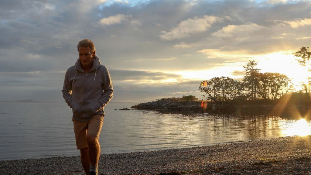 Bărbat în hanorac privind o scenă îndepărtată