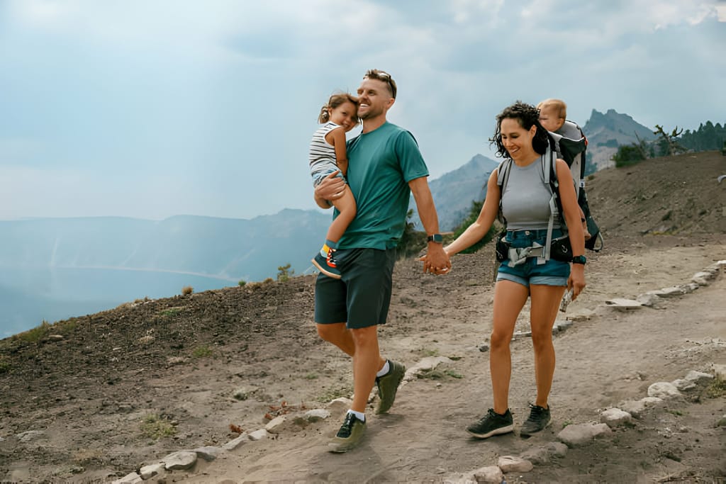 O familie bucurându-se de drumeții în aer liber cu rucsacuri de transport copii
