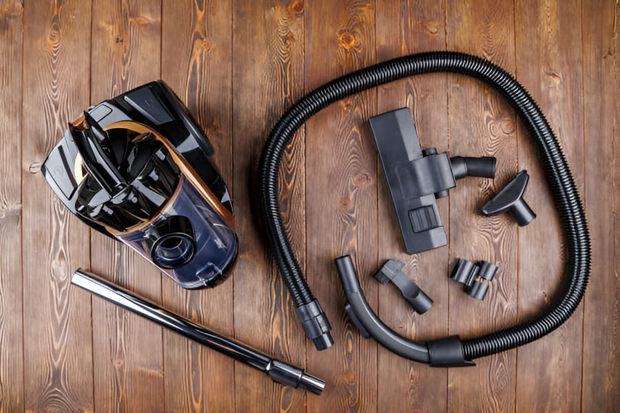 Aspirator fără sac cu accesorii multiple pe podea de lemn
