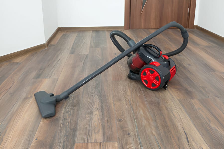 Aspirator fără sac roșu pe podea de lemn