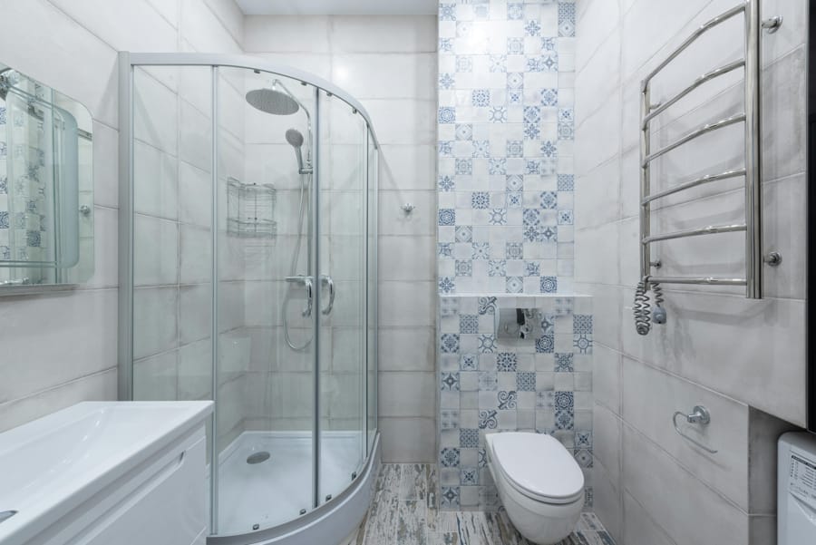 Cabină de duș semirotundă cu uși glisante din sticlă într-o baie modernă decorată