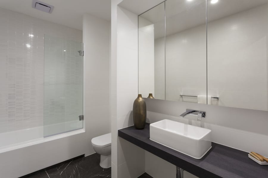 Paravan din sticlă pentru cadă într-o baie modernă, cu finisaje elegante