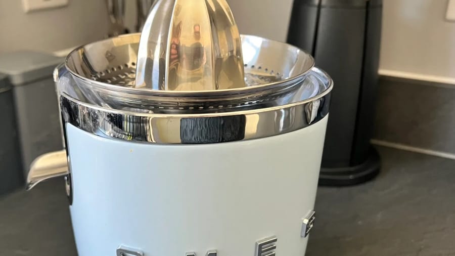 Storcător de citrice modern cu design elegant, metalic și alb.