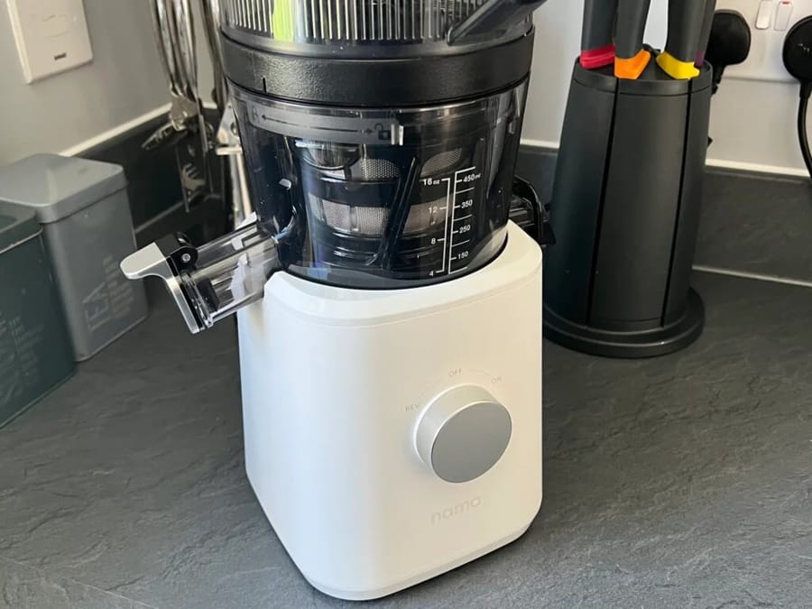 Storcător cu presare la rece, alb, pe blat de bucătărie.