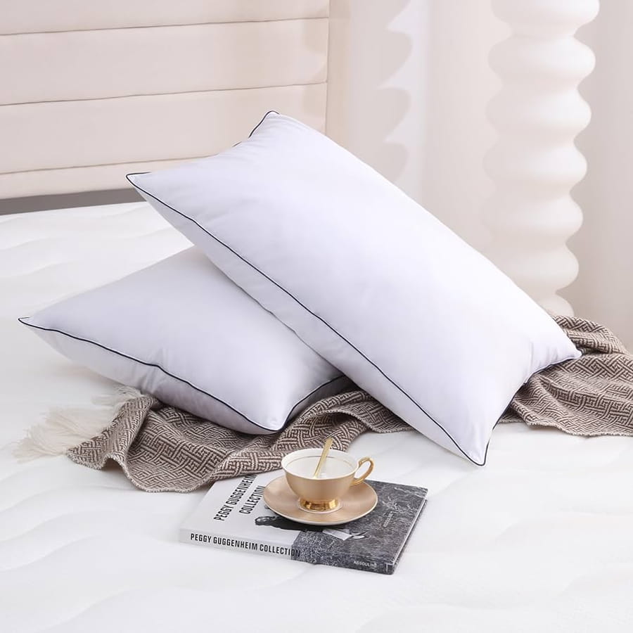 Două perne albe pe un pat, sugerând confort și relaxare