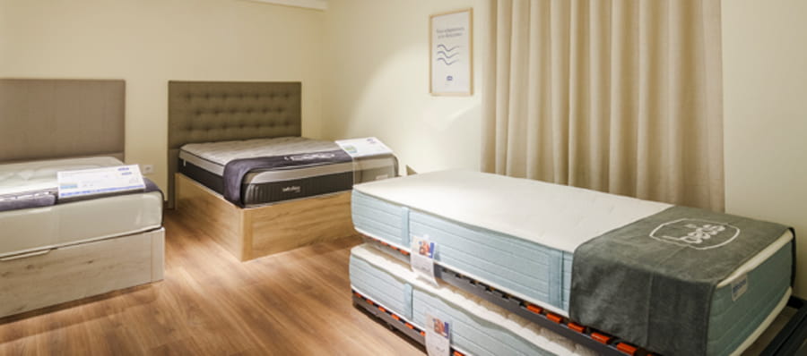 Saltele expuse într-un showroom, disponibile pentru testare, ideale pentru a alege cele mai bune saltele.