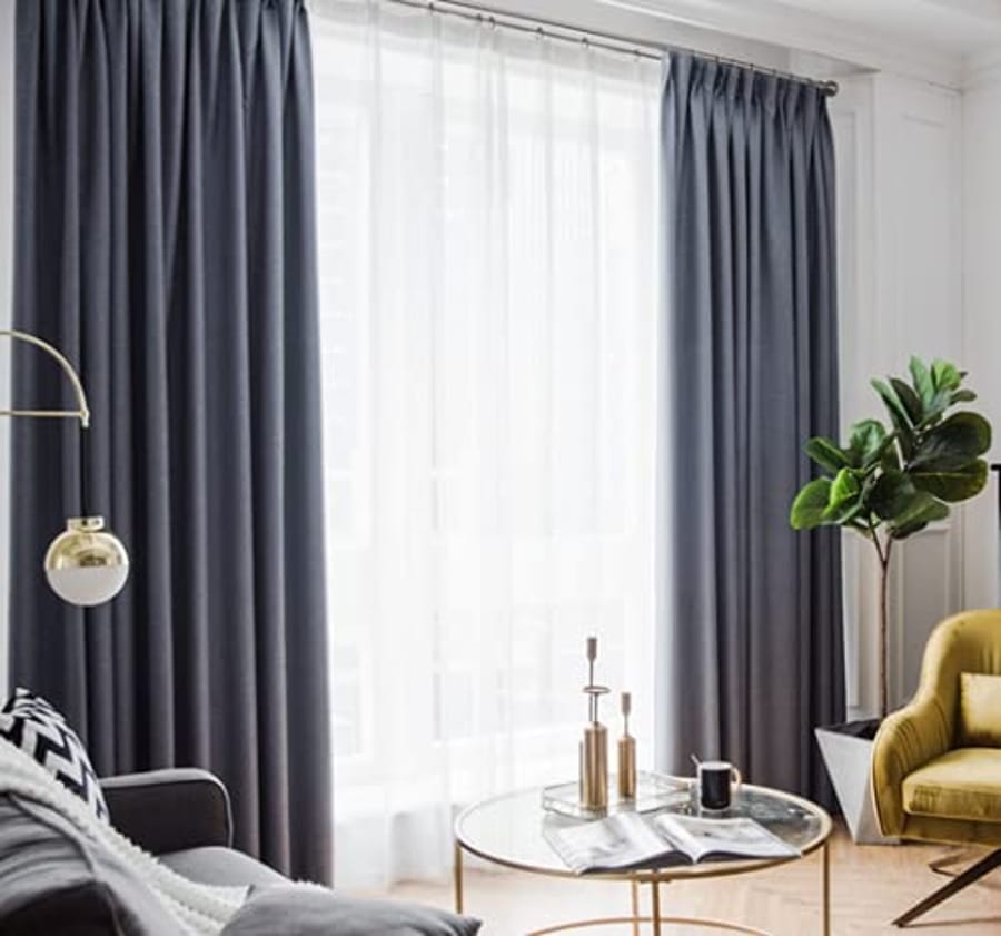 Perdele opace gri și voal alb într-un dormitor elegant