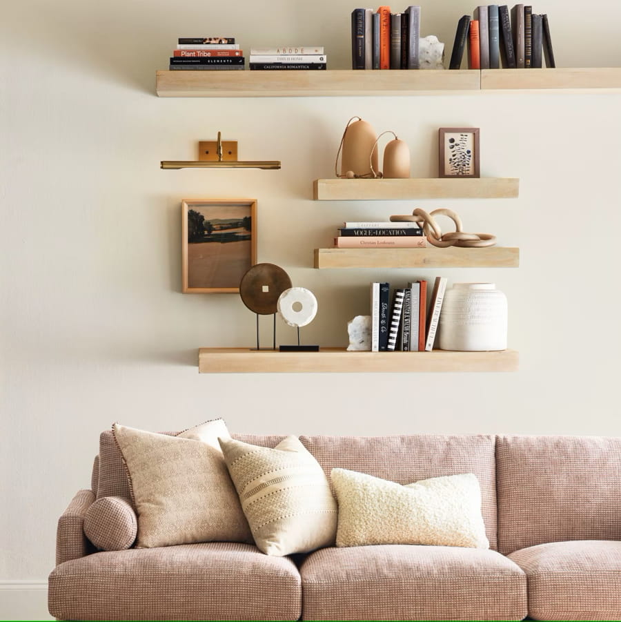 Rafturi decorative de perete din lemn, montate deasupra unei canapele într-un decor modern