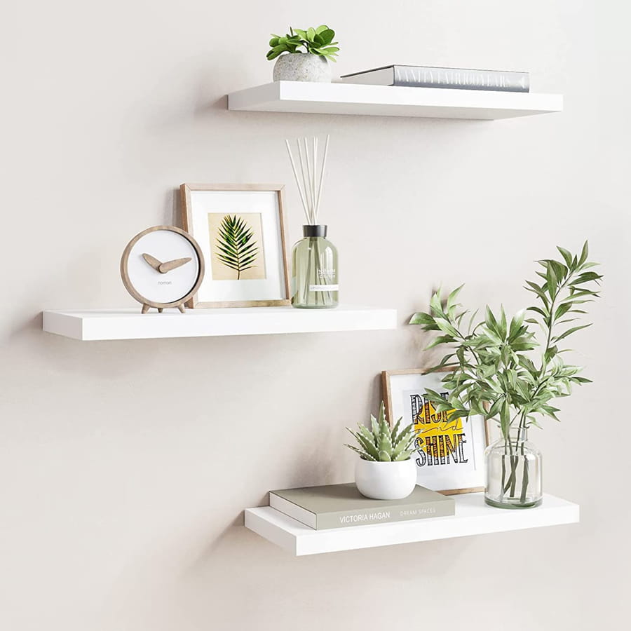 Rafturi decorative montate pe perete cu plante și obiecte decorative