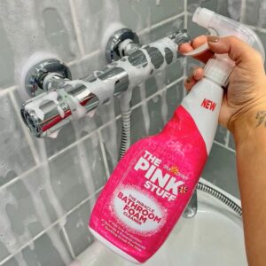 Soluție The Pink Stuff Bathroom Foam Cleaner aplicată pe robinet în timpul curățării.
