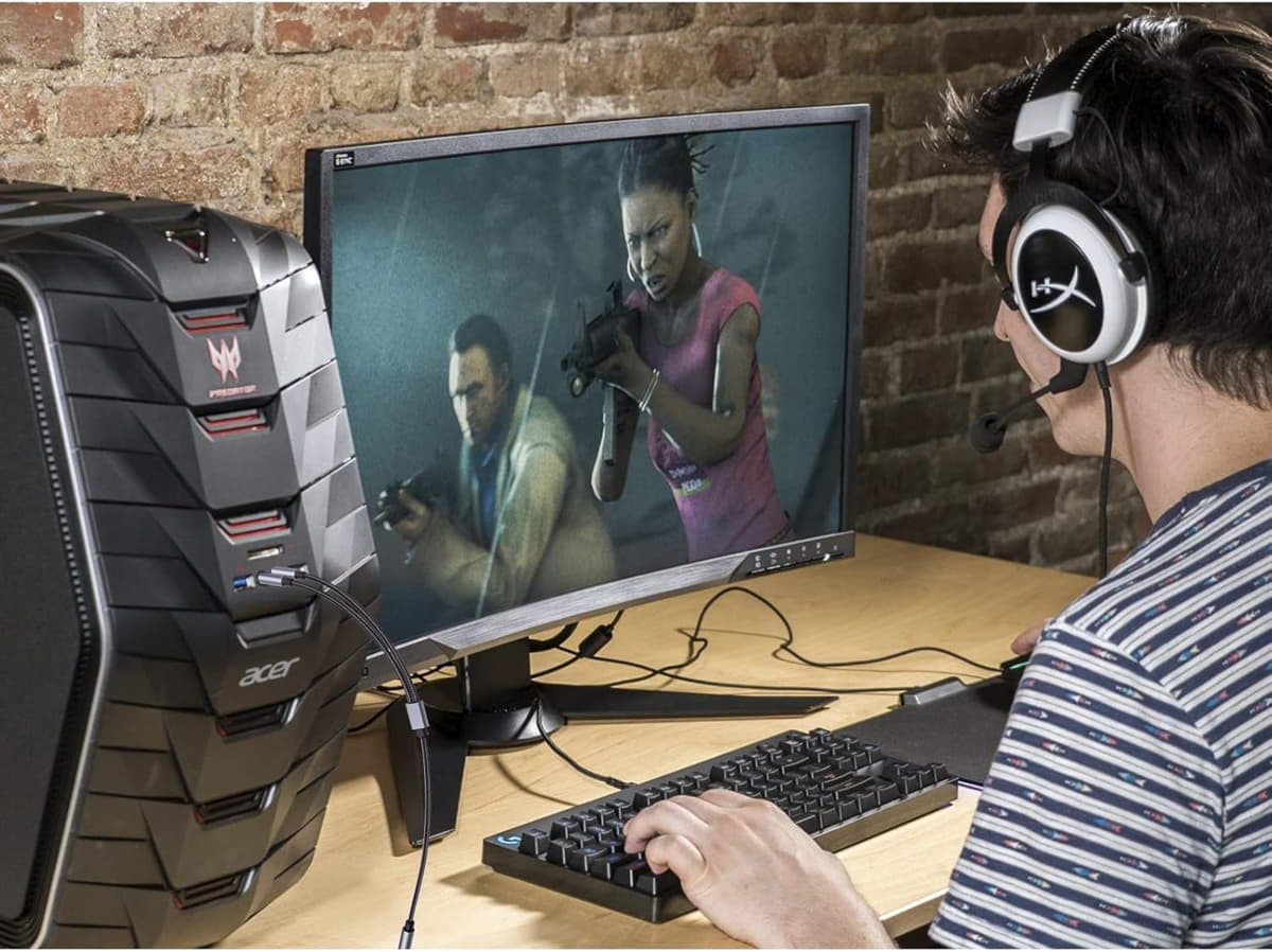 Setup de gaming cu PC, monitor, tastatură și căști.