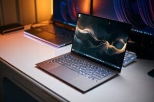 Laptop modern pe birou iluminat, reprezentând cele mai bune laptopuri