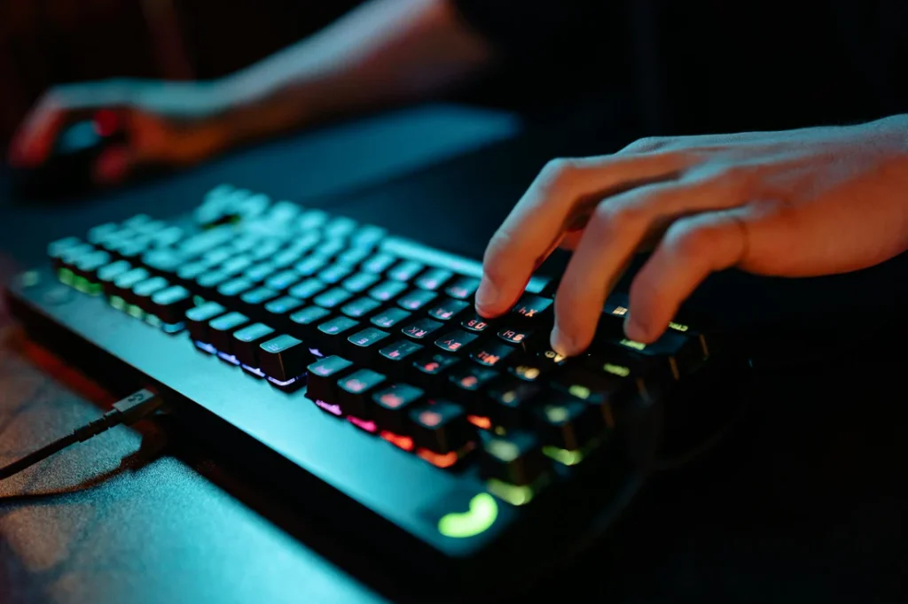 Gamer utilizând o tastatură de gaming iluminată RGB