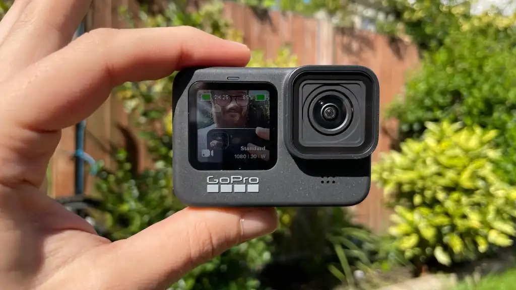 Cameră GoPro ținută în mână, afișând ecranul frontal