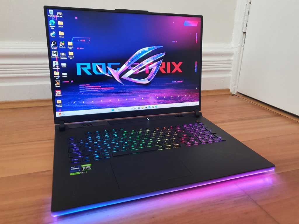 Laptop ASUS ROG Strix G18 deschis pe birou, cu iluminare RGB și ecran de 18 inci