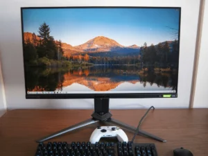 Monitor gaming Acer Predator X28 4K 144Hz cu NVIDIA G-Sync pe birou, alături de tastatură și controller