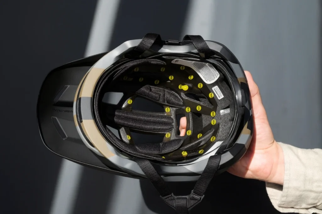 Interiorul unei căști de mountain bike cu sistem MIPS, ținută în mână