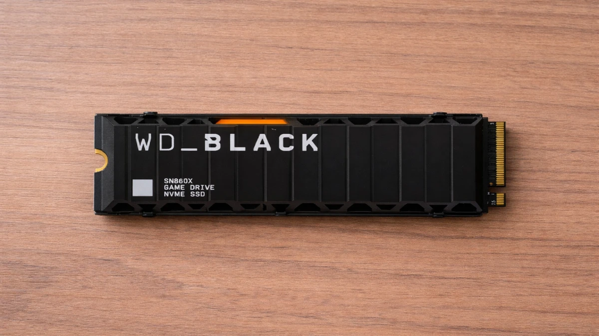 SSD WD Black SN850X 2TB cu heatsink, compatibil PS5, fotografiat pe masă din lemn