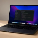 MacBook Air M4 deschis pe un birou de lemn cu ecran macOS activ