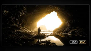 Ecran de televizor afișând o scenă HDR cu contrast extrem — peșteră întunecată și lumină solară intensă în același cadru, cu badge-uri HDR și DV vizibile