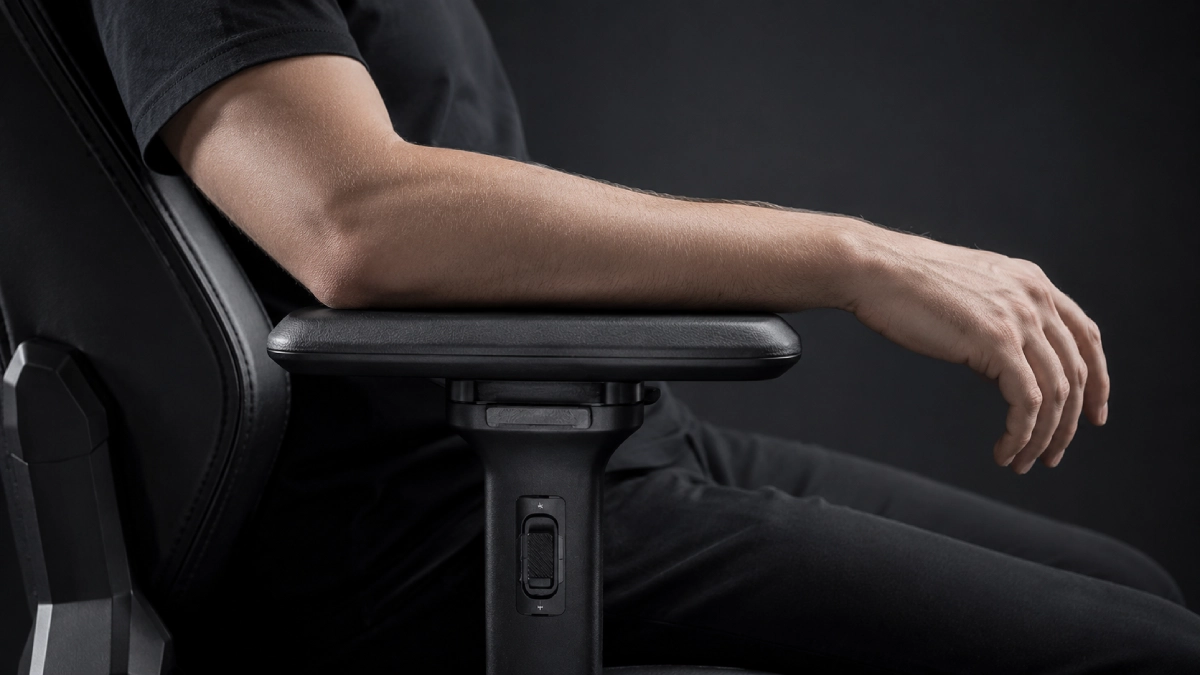 Braț așezat corect pe cotiera unui scaun gaming — cot susținut, antebraț orizontal, poziție ergonomică