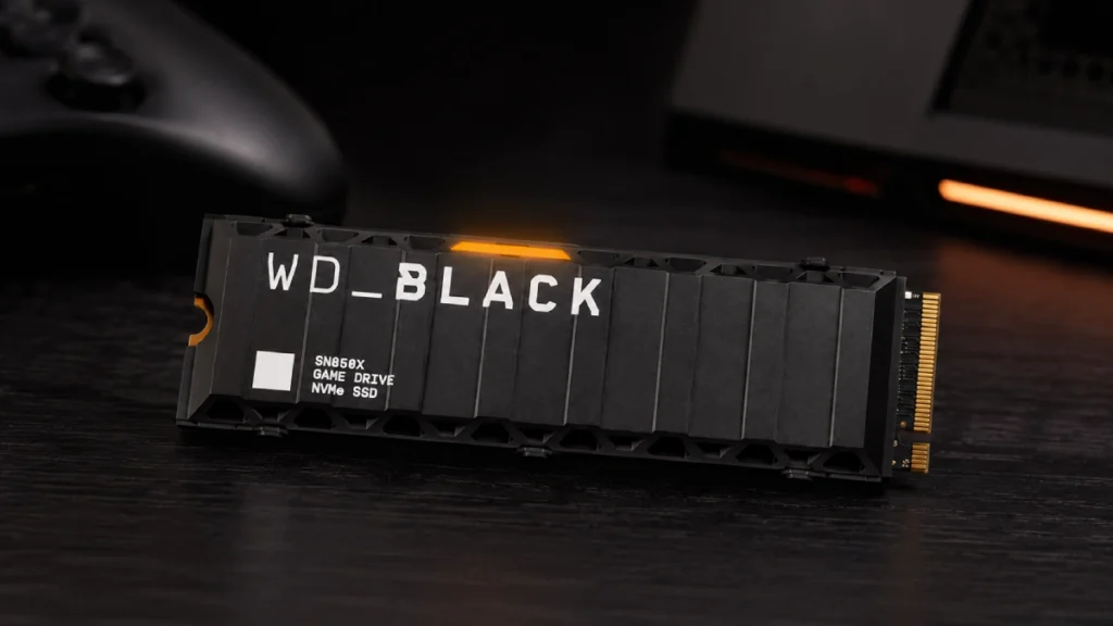 SSD WD Black SN850X 2TB cu heatsink striat și LED portocaliu, așezat pe o masă pregătit pentru montaj pe PlayStation 5