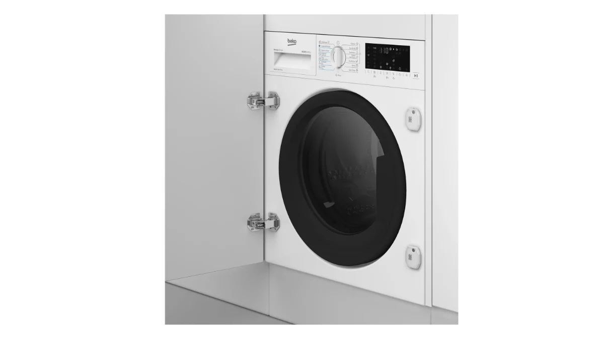 Mașina de spălat rufe cu uscător incorporabilă Beko B5DBT68547W, albă, montată într-un corp de mobilier alb cu ușa deschisă