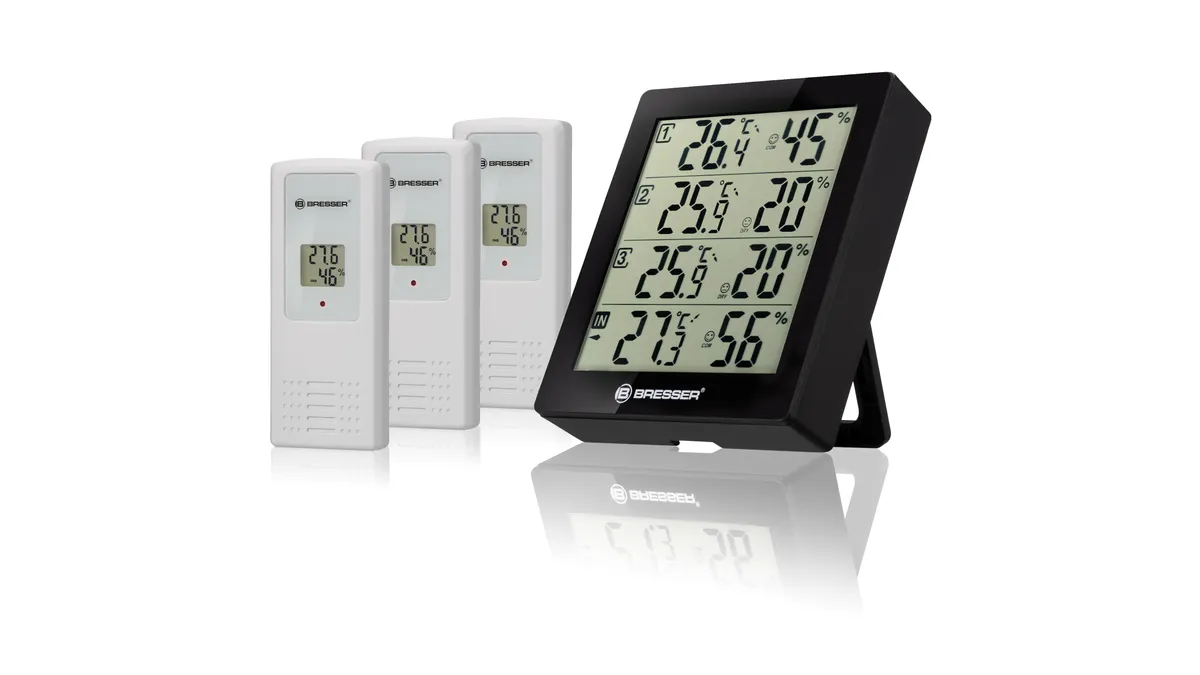 Stația Bresser Thermo-Hygrometer Quadro neagră, cu patru rânduri de valori pe ecran, lângă cei trei senzori wireless albi