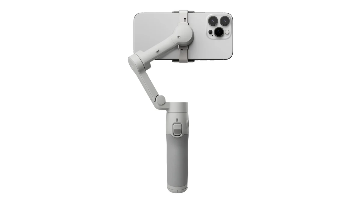 Gimbalul DJI Osmo Mobile 7, gri deschis, cu un iPhone prins în clema magnetică, văzut din spate