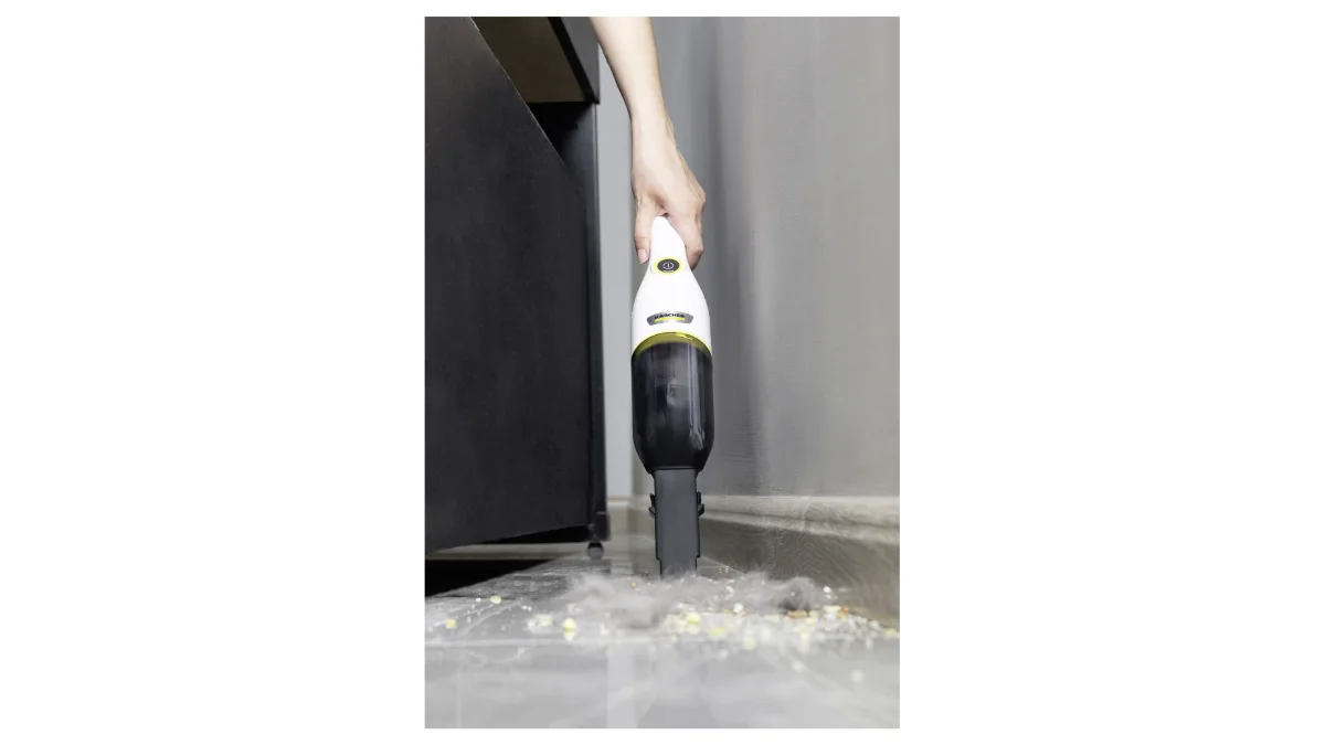 Aspiratorul de mână Kärcher CVH 3 Plus alb, folosit pe o podea cu firimituri