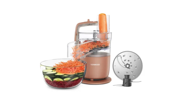Robotul de bucătărie compact Kenwood MultiPro Go FDP23.140RD, în culoarea Clay Red, cu accesoriul Express Serve care rade morcovi într-un bol