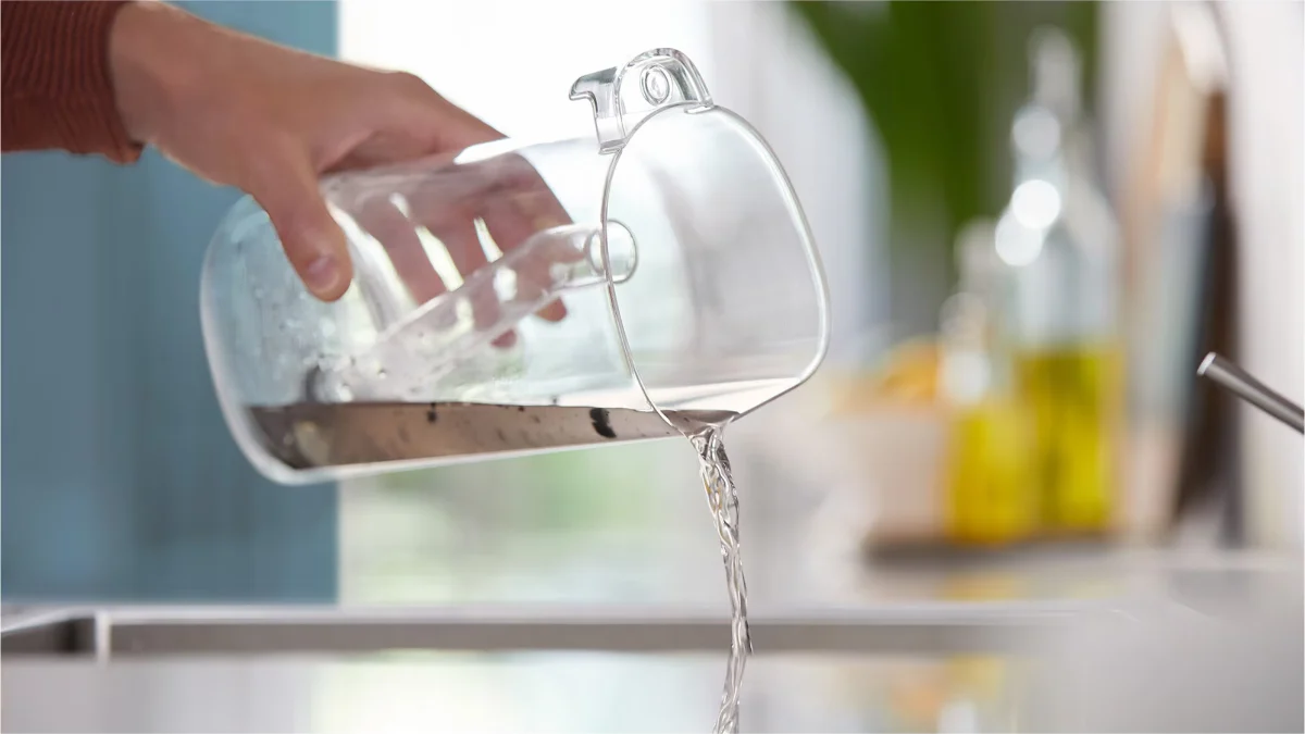 Rezervorul de apă al aspiratorului Philips AquaTrio 9000 golit deasupra chiuvetei