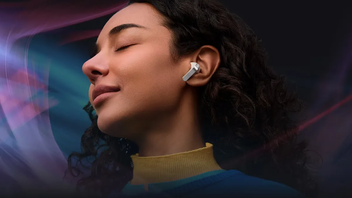 Femeie cu ochii închiși, în profil, care ascultă muzică cu o cască Samsung Galaxy Buds4 Pro albă în ureche, pe un fundal întunecat cu unde colorate