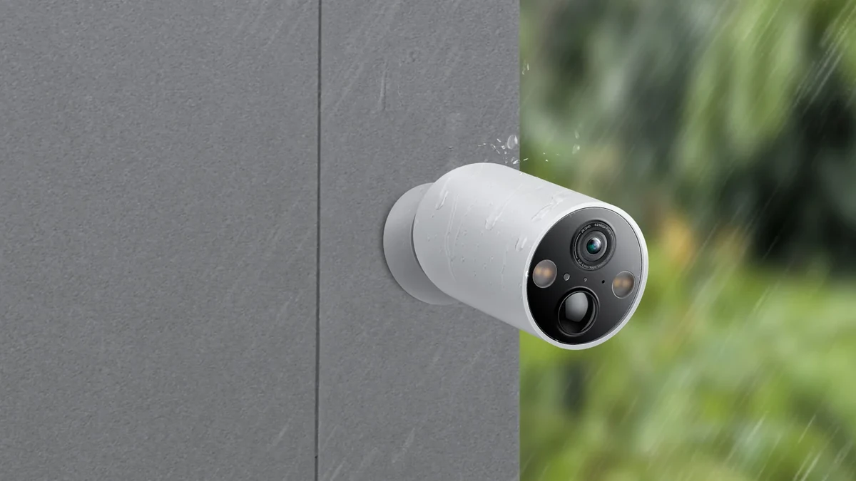 Camera Tapo C425 montată pe un perete gri, cu stropi de ploaie pe carcasă