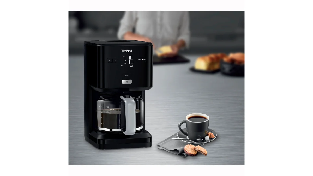 Cafetiera Tefal Smart’n Light CM600810 neagră, cu ecranul digital aprins, pe un blat lângă o ceașcă de cafea