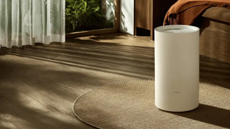 Dezumidificatorul Xiaomi Smart Dehumidifier Lite, un cilindru alb, așezat pe un covor rotund într-un dormitor luminat de soare